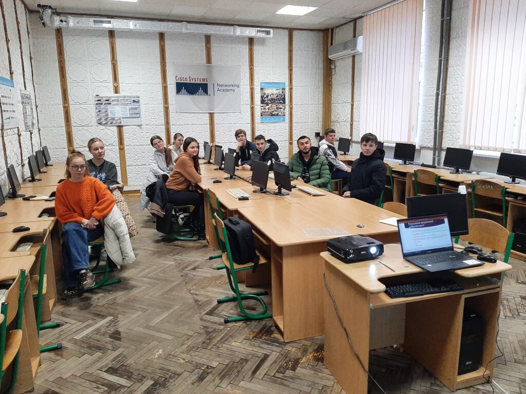 A group of people sitting in a room with computers